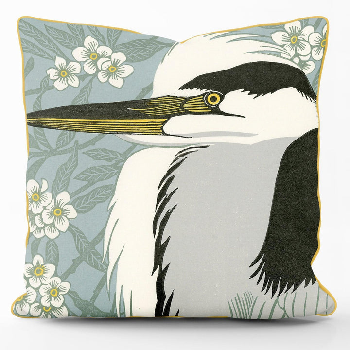 A piped cushion with a picture of a bittern on. Small flowers in the background.
