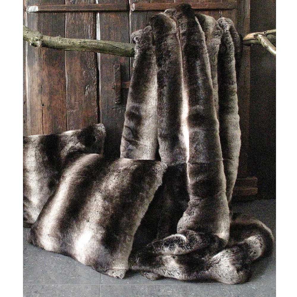 striped brown faux fur throw draped over rustic backdrop