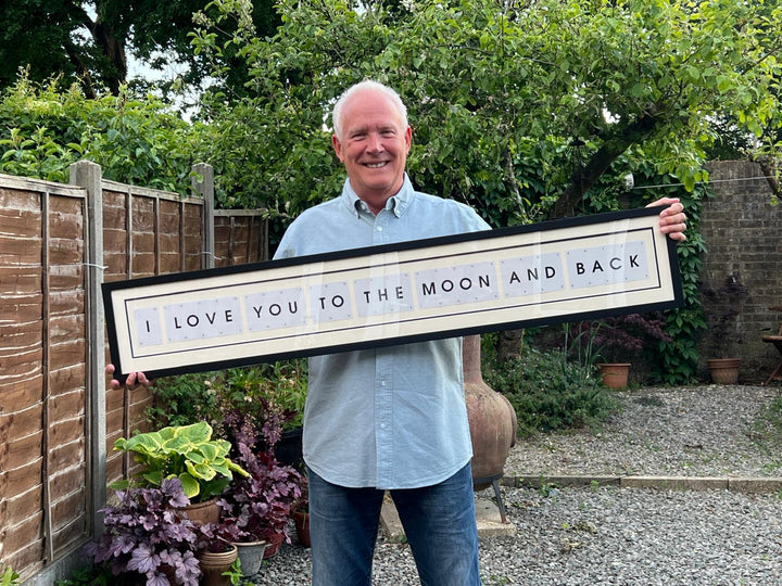 Man holding a framed quote &