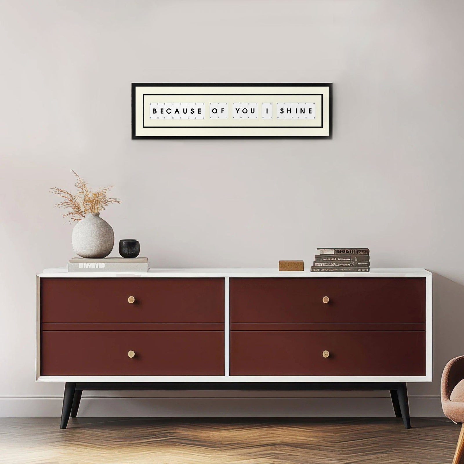 Because of You I Shine playing card picture frame displayed on a grey wall above a modern wooden chest
